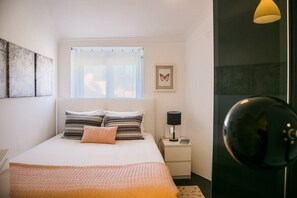 1 dormitorio y tabla de planchar con plancha