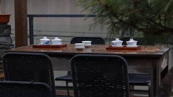 A dining table with white dishes and a tray, surrounded by black chairs.