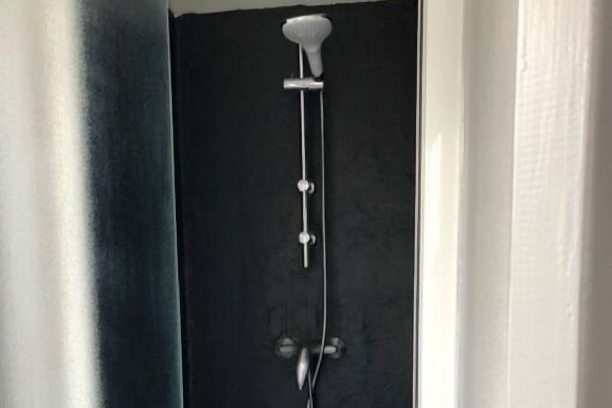 A bathroom with a shower, a toilet, and a sink.