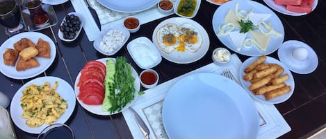 A table set with various dishes including eggs, salads, and bread, suggesting a breakfast setting.
