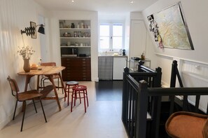 Een keuken met een eethoek, houten kasten en een kaart aan de muur.