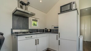 A modern kitchen with white cabinets, a gas stove, a microwave, and a built-in oven.