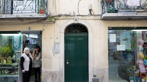 A building with a green door and numbered windows 11 and 13.