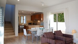 A modern interior with a staircase, a dining area, and a kitchen. - Carob Tree villa near The Centre (Latsi)