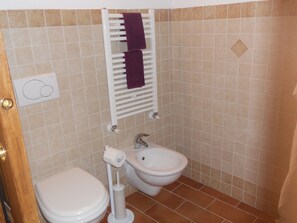 A bathroom with a toilet, bidet, and towel rack. - Apartment in a farmhouse a few km from the center (Siena)