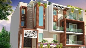 A modern multi-story building with a mix of brick and glass facades, balconies, and decorative plants.