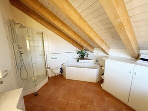Ein Badezimmer mit Duschkabine, Toilette, Badewanne und Schrank.