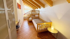 Une pièce avec un lit superposé, une petite table et un escalier menant à un niveau supérieur.