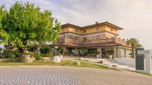 Un immeuble à plusieurs étages doté d’une cour intérieure, de grandes fenêtres et d’une enseigne indiquant qu’il s’agit d’un hôtel de luxe.