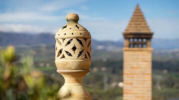 Un vaso decorativo con motivi intricati, una torre in mattoni e un paesaggio lontano.