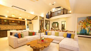 A spacious living area with two sofas, a coffee table, and a kitchen in the background. - Villa Aveli Seminyak by Best Deals Asia Hospitality (Seminyak)