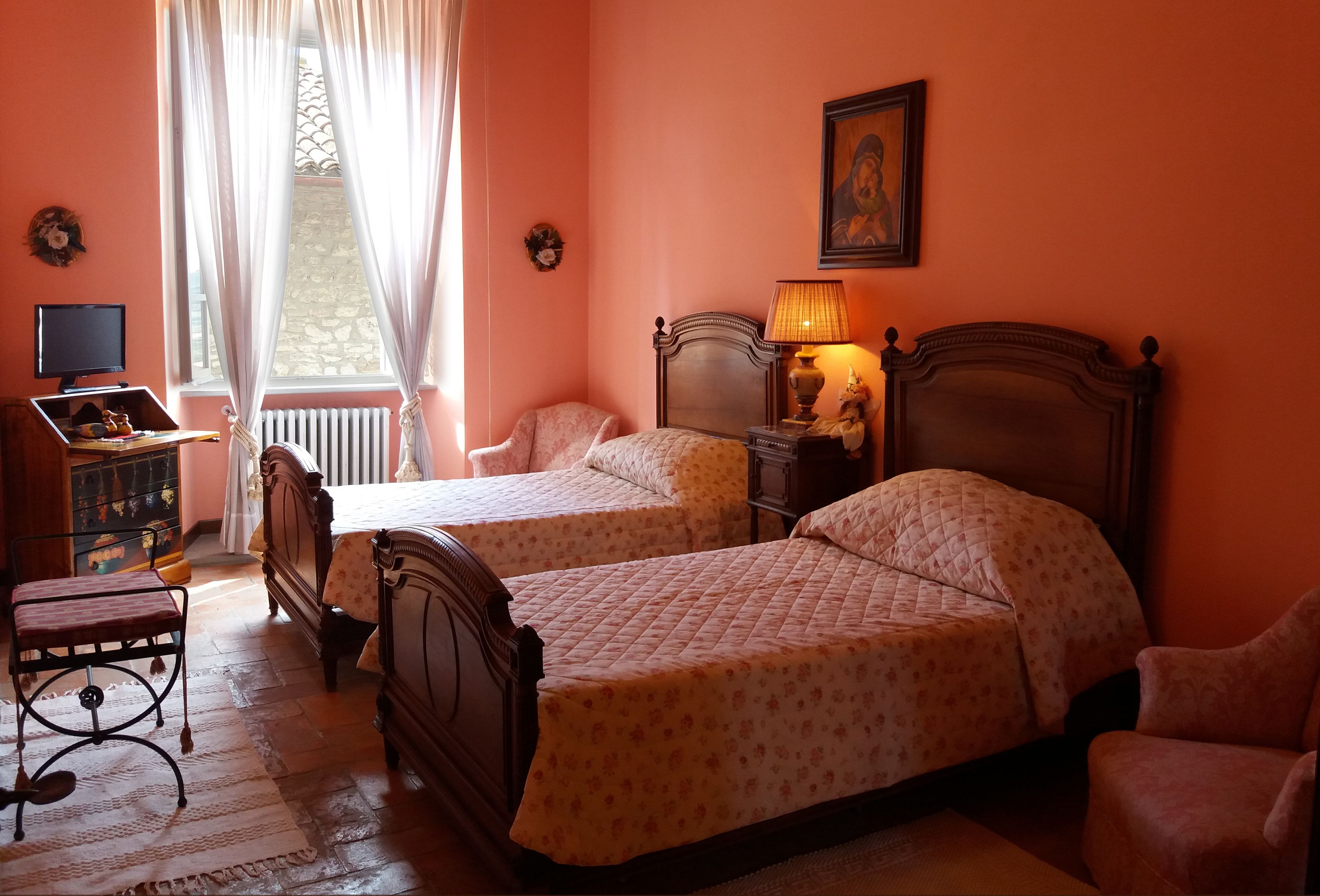 Un dormitorio con dos camas, un escritorio y una silla.