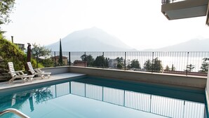 Piscina con vista a montañas y barandilla.