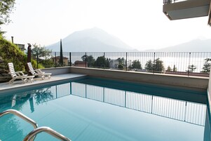 Piscina com vista para montanhas e guarda-corpo.