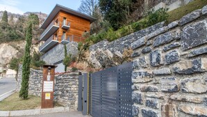 Un edificio moderno con un muro de piedra y una reja de metal.