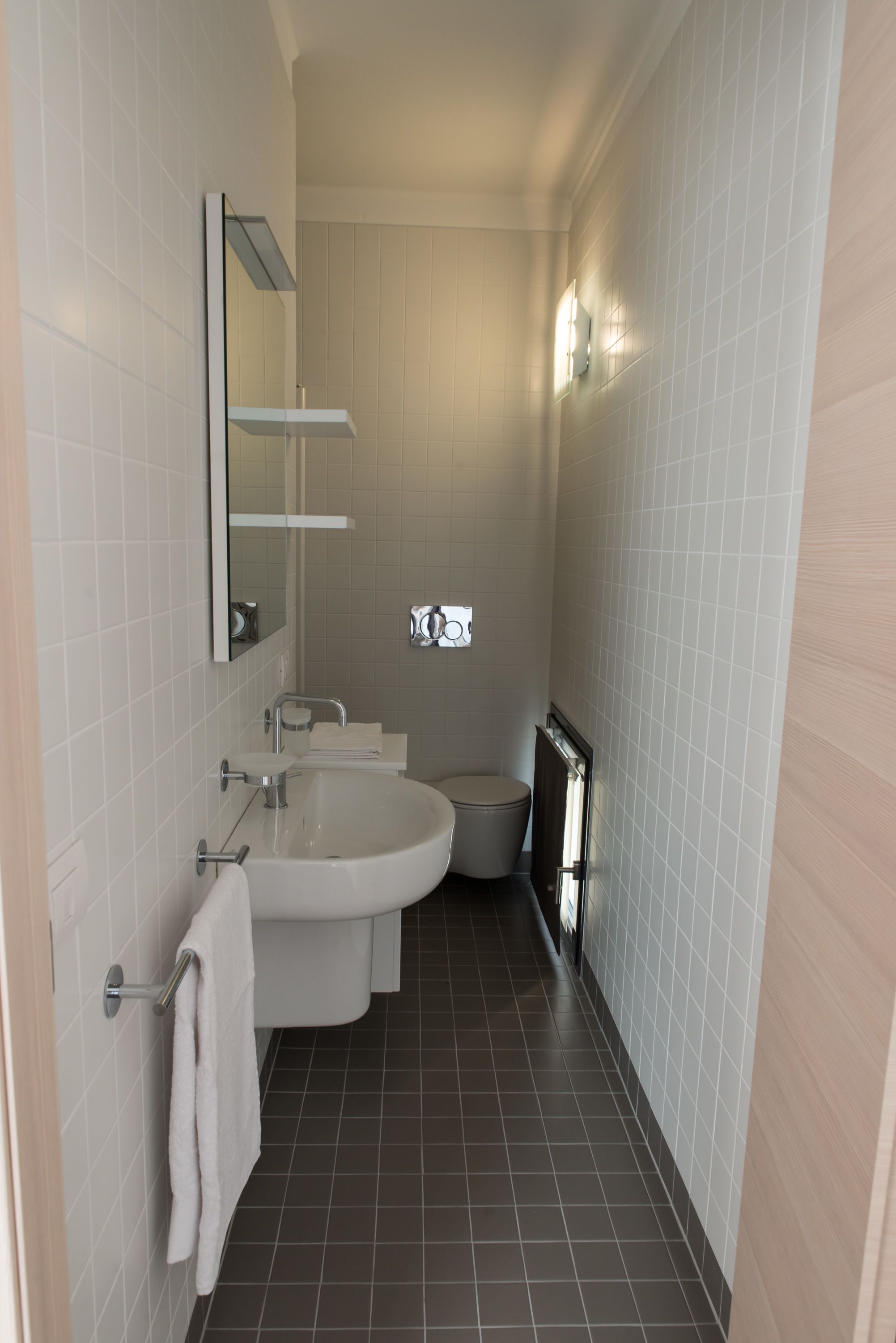 Une salle de bain moderne avec un lavabo, un miroir et des toilettes.