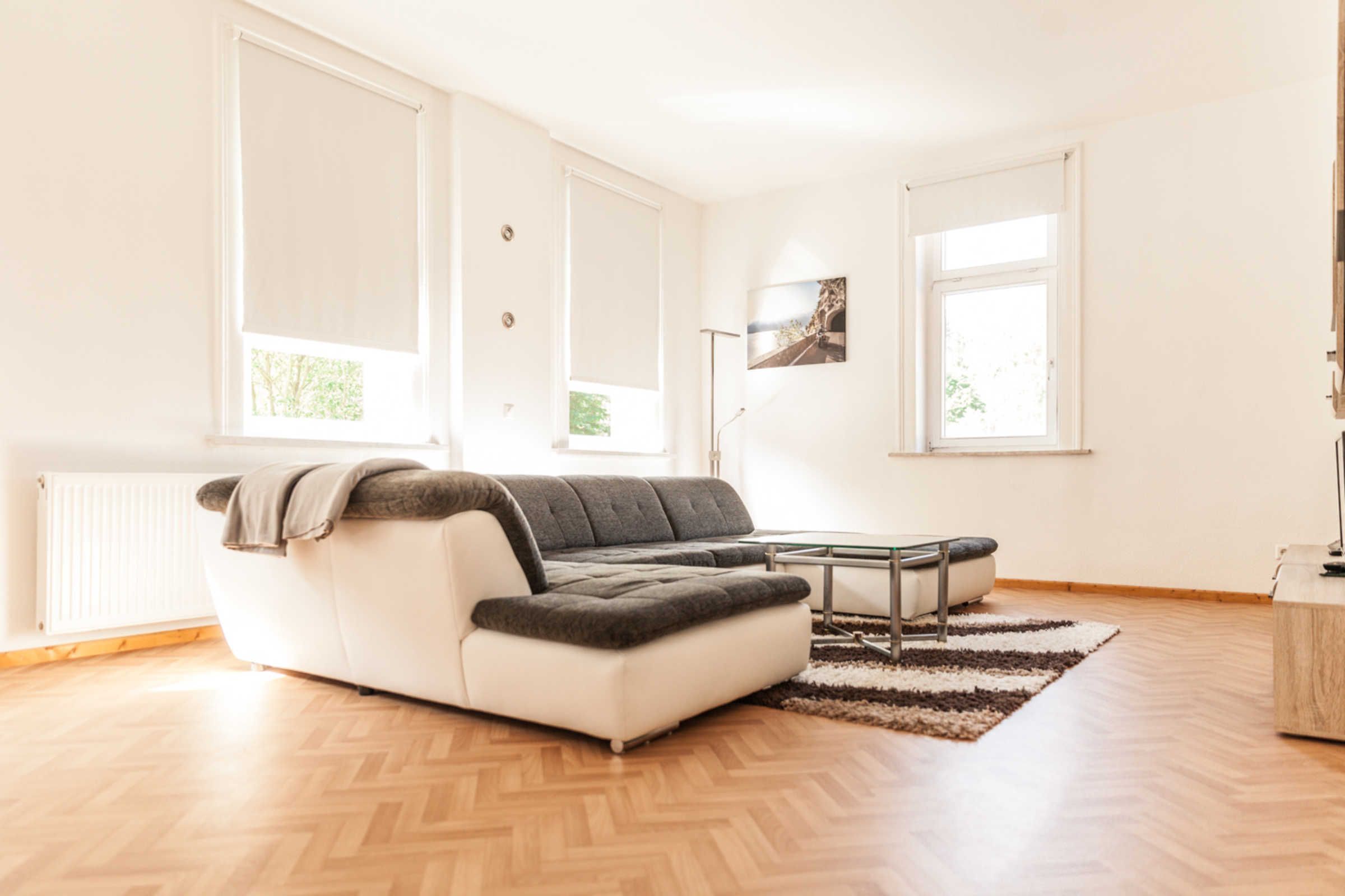 Una sala de estar moderna con un sofá seccional, una mesa de centro y un ventanal grande.