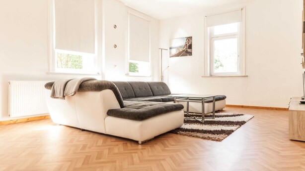En moderne stue med en modulsofa, et sofabord og et stort vindue.