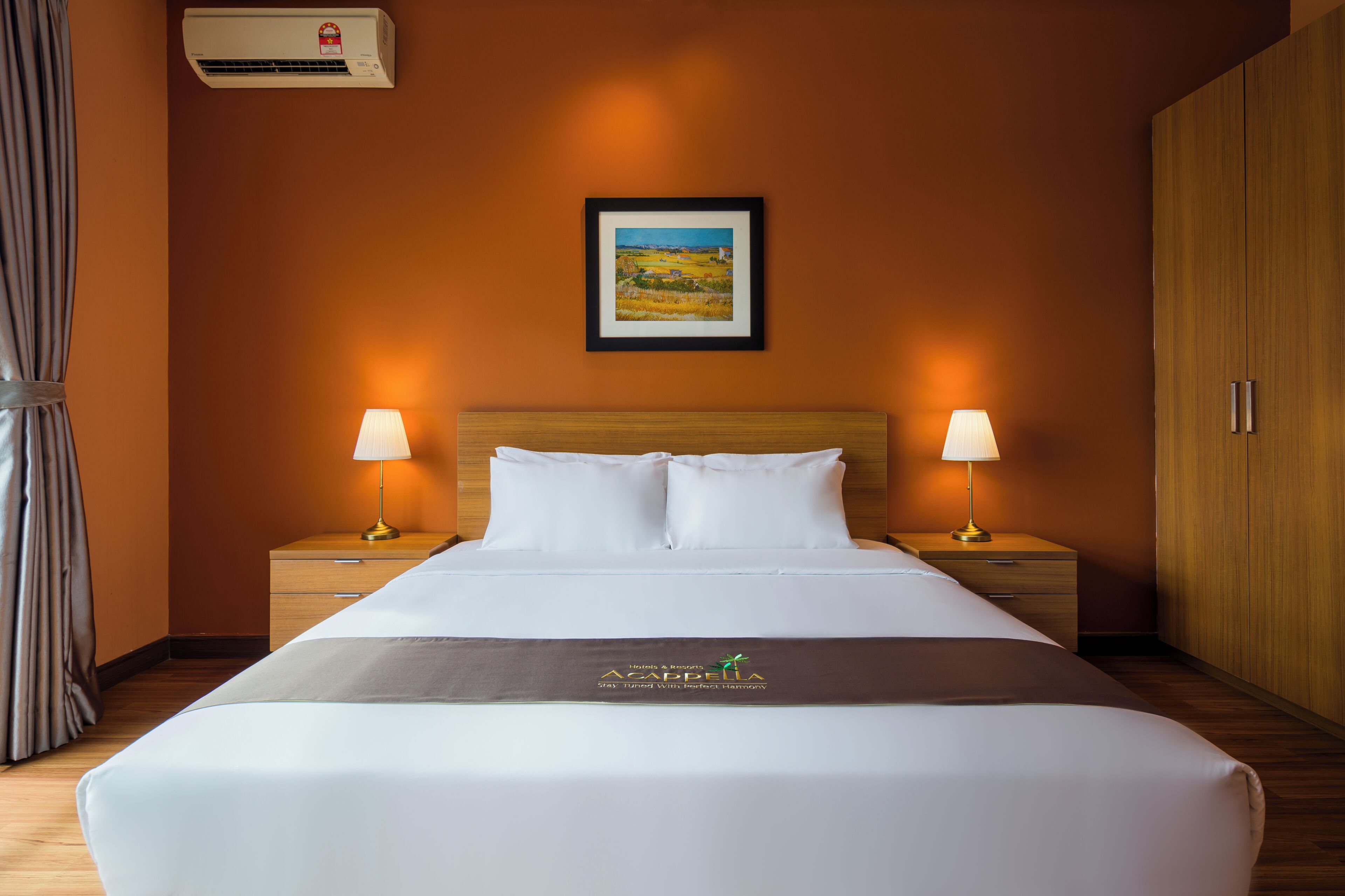 Una habitación de hotel con una cama, dos mesitas de noche con lámparas, un cuadro enmarcado en la pared y un armario.