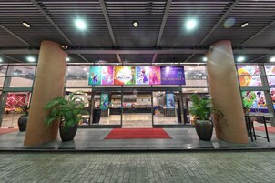 Entrada de hotel con pilares grandes, alfombra roja y banderines con temática de Disney.
