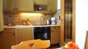 Une cuisine avec des meubles de rangement en bois, un évier, une cuisinière et une machine à café.