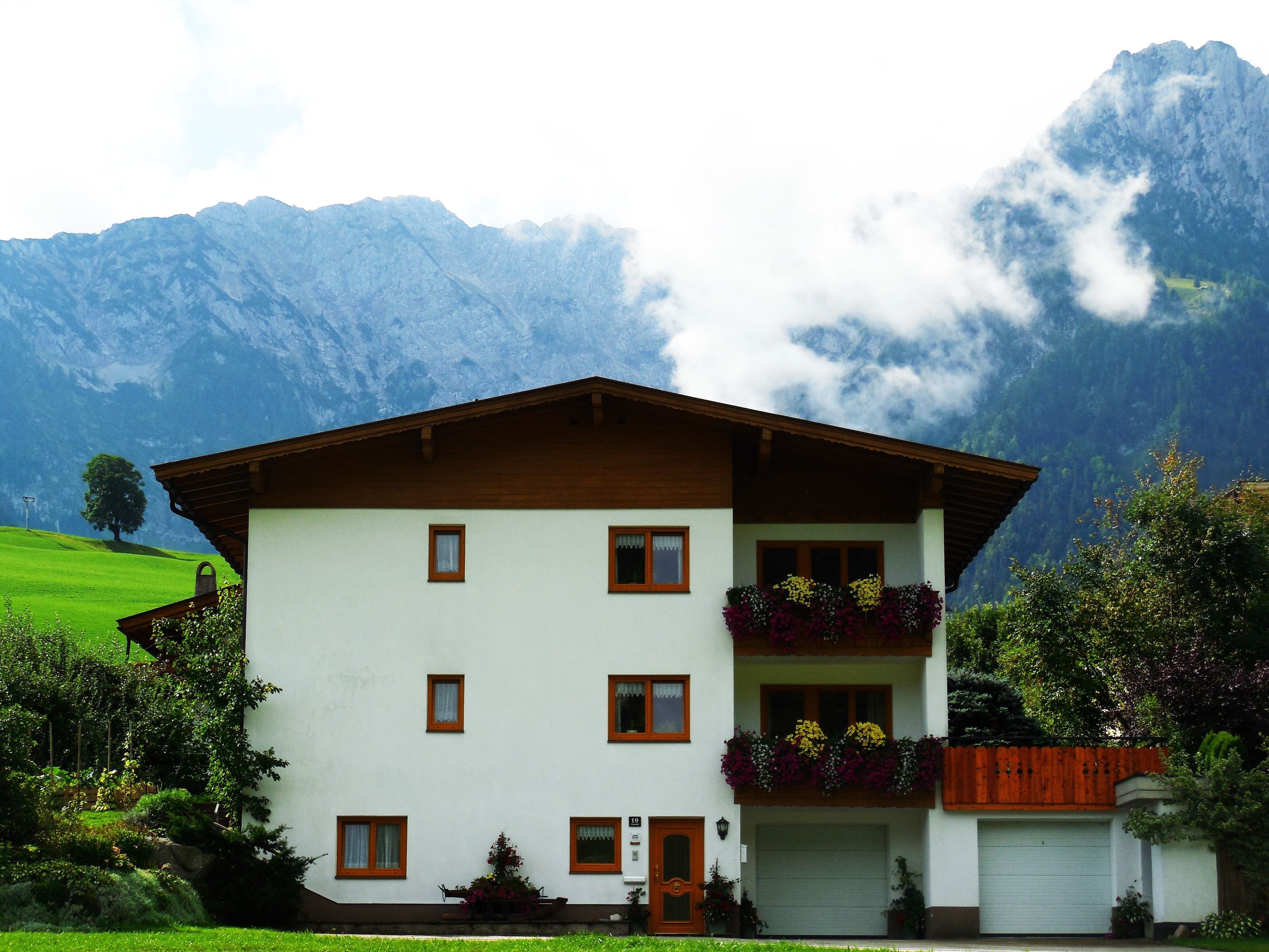 A two-story building with a white facade, brown roof, and multiple windows.