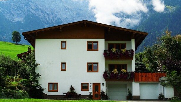 Un bâtiment à deux étages, doté d’une façade blanche, d’un toit brun et de nombreuses fenêtres.