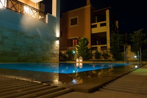 Una piscina al aire libre, sombrillas, tumbonas