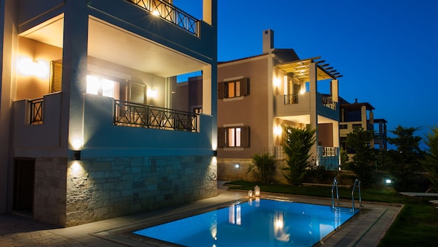 A modern two-story building with a swimming pool, balconies, and outdoor lighting. - Harmony of Nature villa (Rethymno)