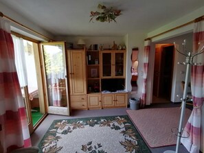 A room with a wooden cabinet, a patterned rug, and a ceiling fan.