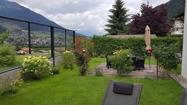 Een tuin met uitzicht op een stad en bergen.