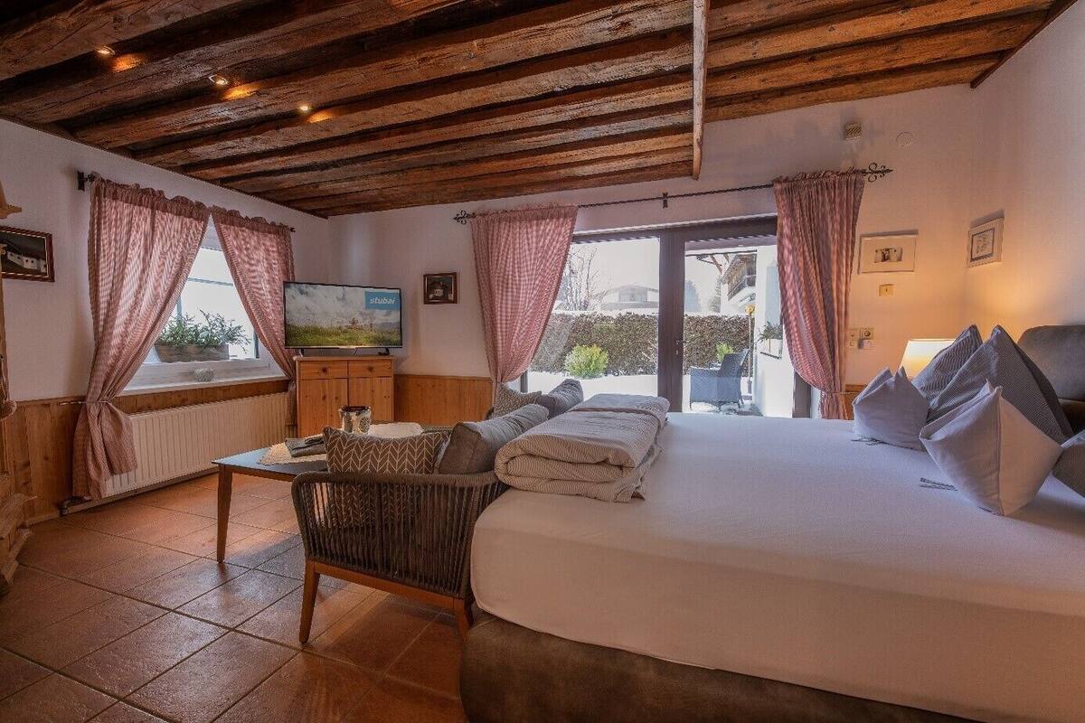 Een gezellige slaapkamer met een bed, een televisie en uitzicht op het omliggende landschap.