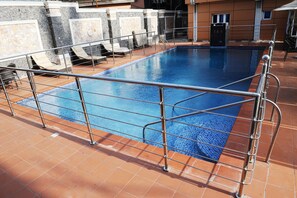 Piscine couverte, piscine extérieure, parasols de plage, chaises longues