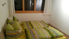 A bedroom with two beds, each with patterned bedding. - Apartment Simone - Apartment Simone (Schoppernau)