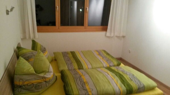 A bedroom with two beds, each with patterned bedding.