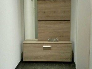 Un rincón con un aparador de madera y una pequeña cómoda.