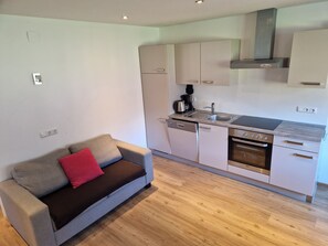 A compact kitchen with white cabinets, a built-in oven, and a coffee maker. - Apartment Simone - Apartment Simone (Schoppernau)