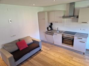A compact kitchen with white cabinets, a built-in oven, and a coffee maker. - Apartment Simone - Apartment Simone (Schoppernau)