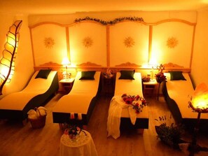 Una habitación con dos camas, cada una con una mesita de noche y una lámpara.
