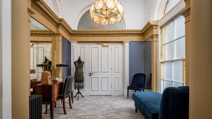 A hallway with a mannequin in a dress, a blue chair, and a blue sofa. - Number 31 (Dublin)