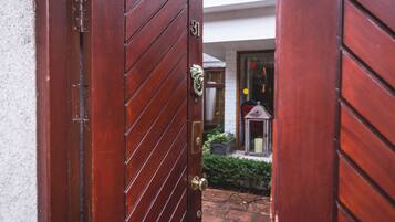 Una puerta de madera con una placa de número de latón y un llamador de latón.