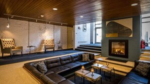 A modern lounge area with leather sofas, a fireplace, and a stone wall. - Number 31 (Dublin)