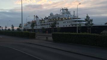 Un gran crucero amarrado en un puerto con cielo despejado y atardecer.