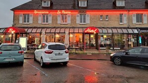 A building with a restaurant and a hotel. There are cars parked in front. - Hôtel du Phare (Ouistreham)