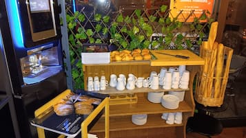 A café interior with a coffee machine, pastries, and a menu display.