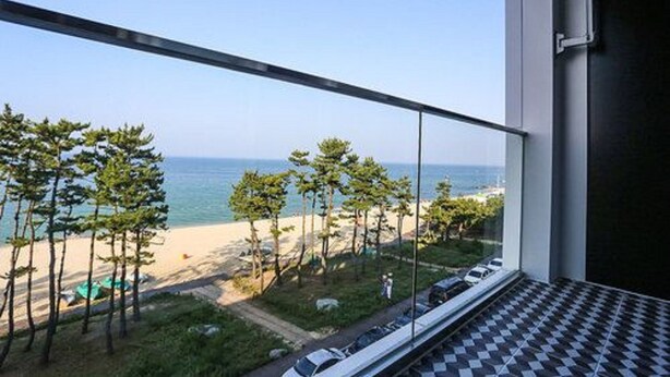 A balcony with a view of the beach and ocean.