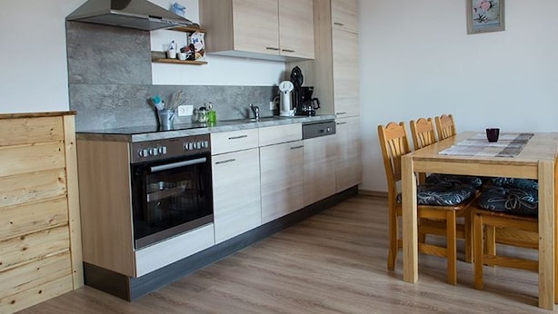 A modern kitchen with a built-in oven, a coffee machine, and wooden cabinets. - Large apartment with lake view - family holiday Stabauer (4 flowers) (Lindau)