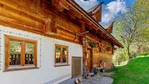Une maison en bois avec un chemin de pierre, un banc en bois et une porte.
