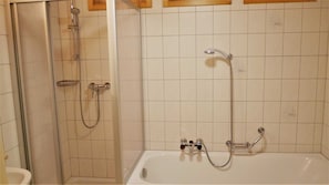 A bathroom with a shower, a bathtub, and a toilet.