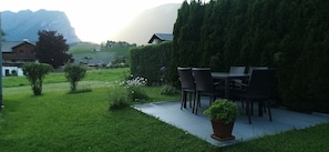 A patio with outdoor furniture, a potted plant, and a hedge. - Vacation with Moses - Holiday apartment (Schoppernau)